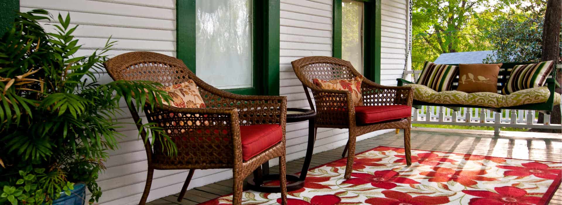 chairs on red flower rug and a porch swing
