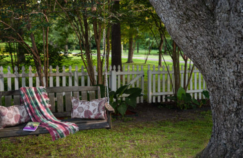 tree swing with a red and green blanket on the arm