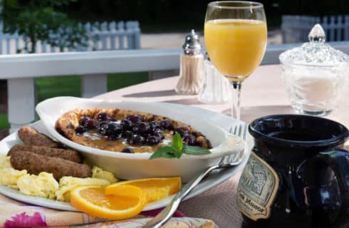 blueberry pancakes in a white dish with oranges