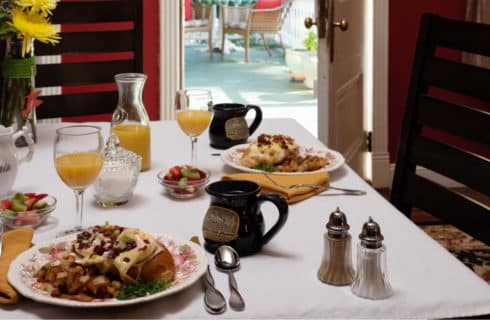 breakfast table with food, juice and coffee