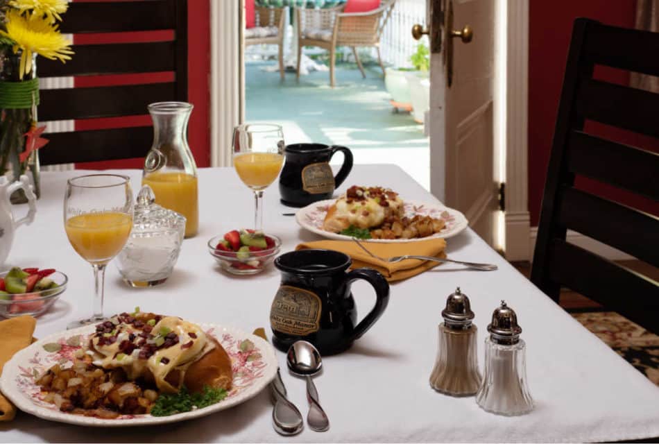 breakfast table with food, juice and coffee