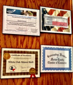 framed certificates and business licenses on a wooden wall