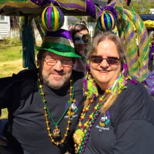 people dressed in purple, green and gold for mardi gras