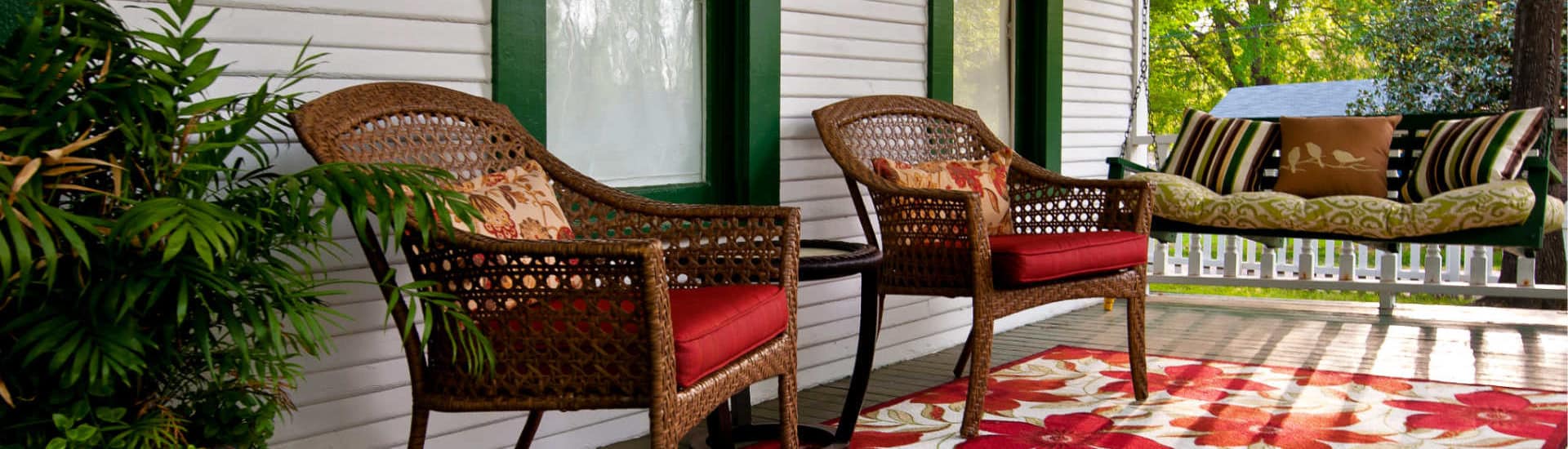 chairs on red flower rug and a porch swing