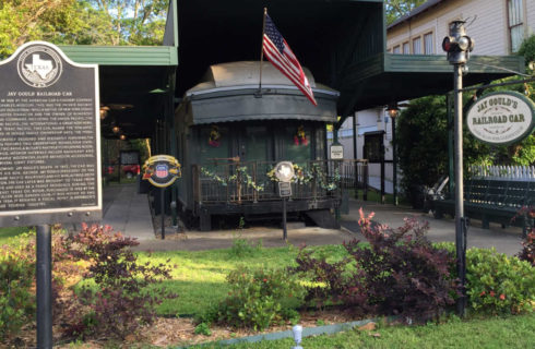 old railway car under a cover with historic signs all around