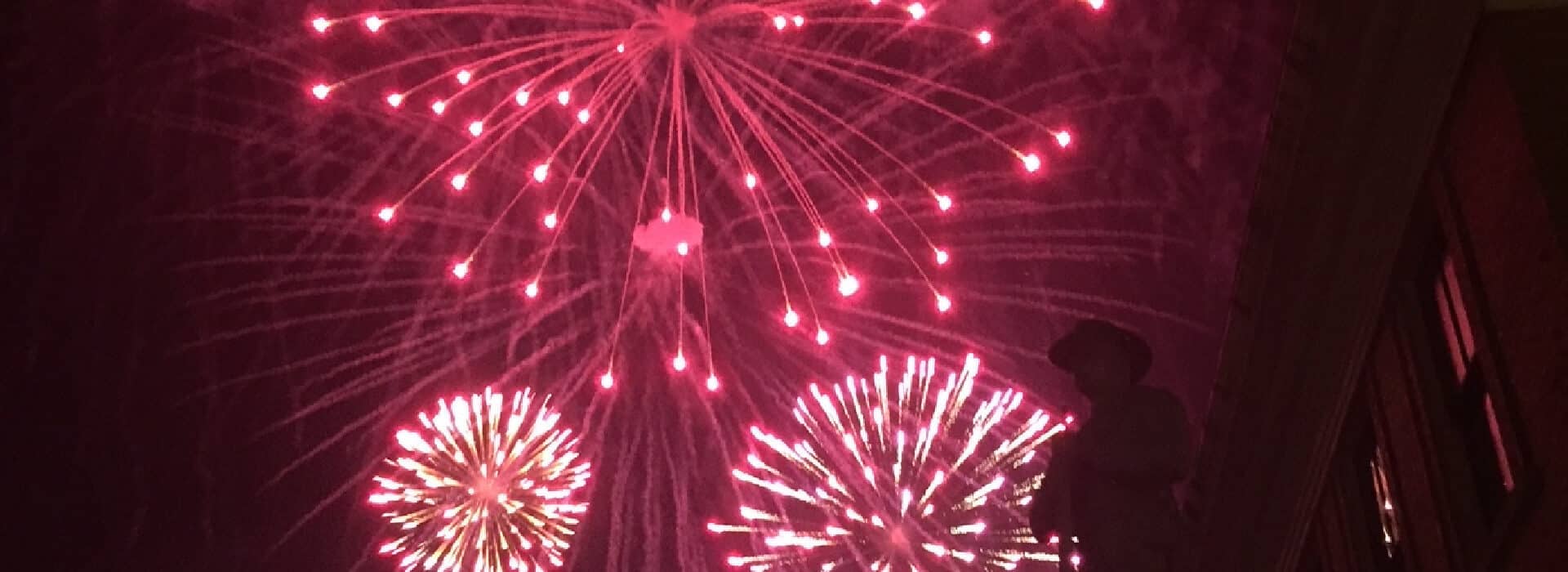 black night sky with 3 red starburst fireworks