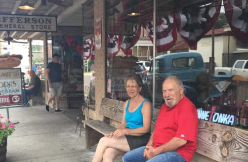 man and women sitting on a bench in front of a store