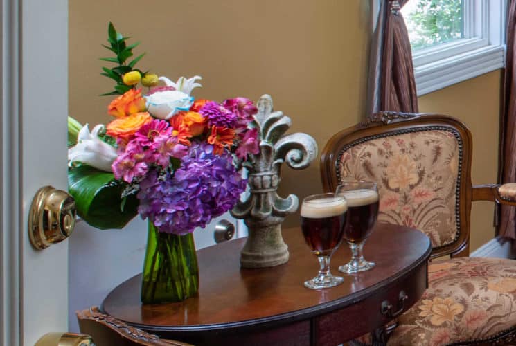 wodden table with a bouquet of flowers and beer glasses on it