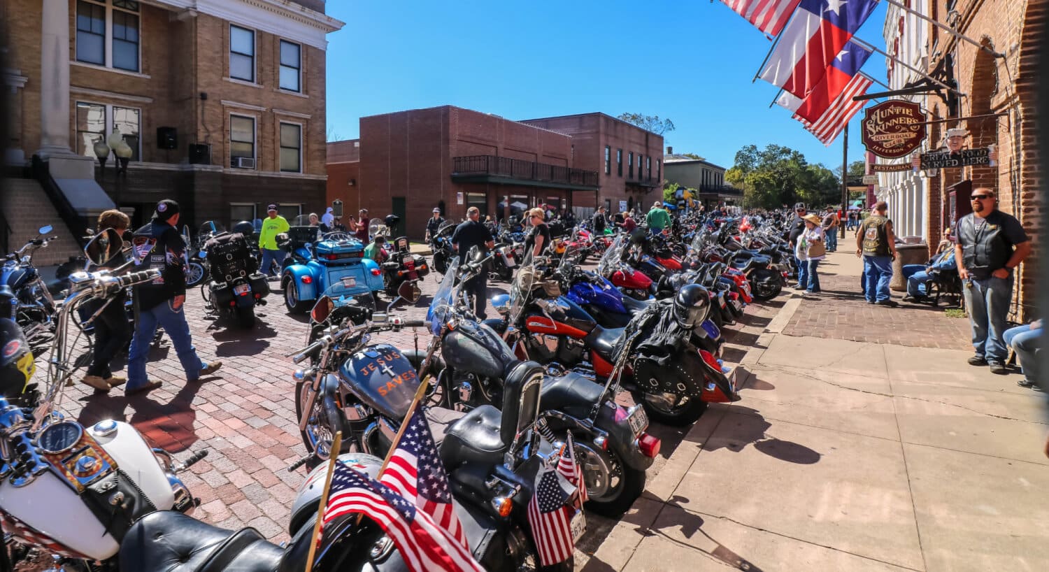 Hundreds of motorcyles parked on display on a cobblestone street