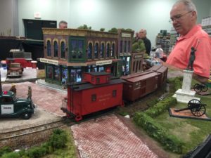 a model scale red caboose traveling down the track